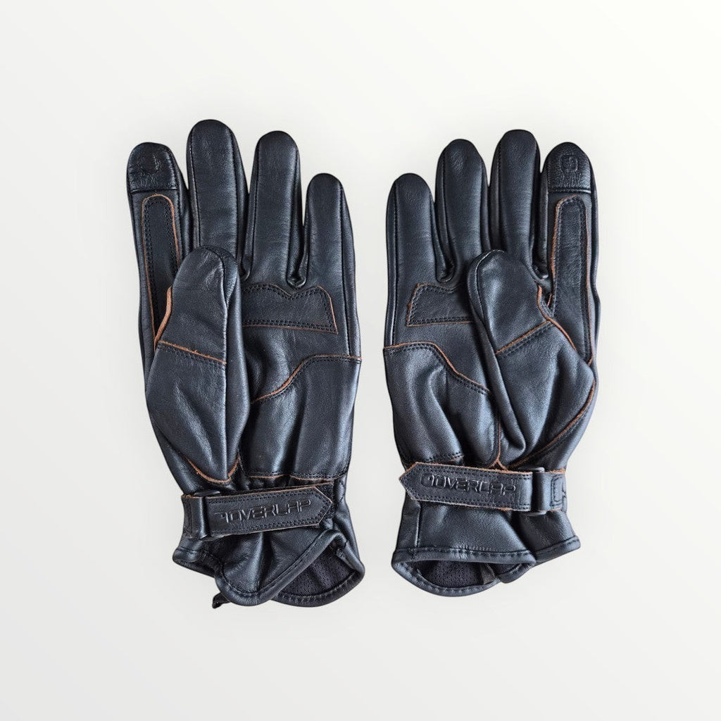 VelvetMoto black leather riding gloves with contrast stitching and adjustable wrist straps.