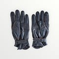 VelvetMoto black leather riding gloves with contrast stitching and adjustable wrist straps.
