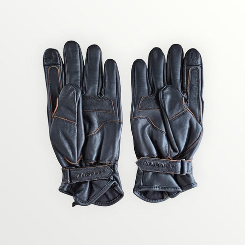 VelvetMoto black leather riding gloves with contrast stitching and adjustable wrist straps.