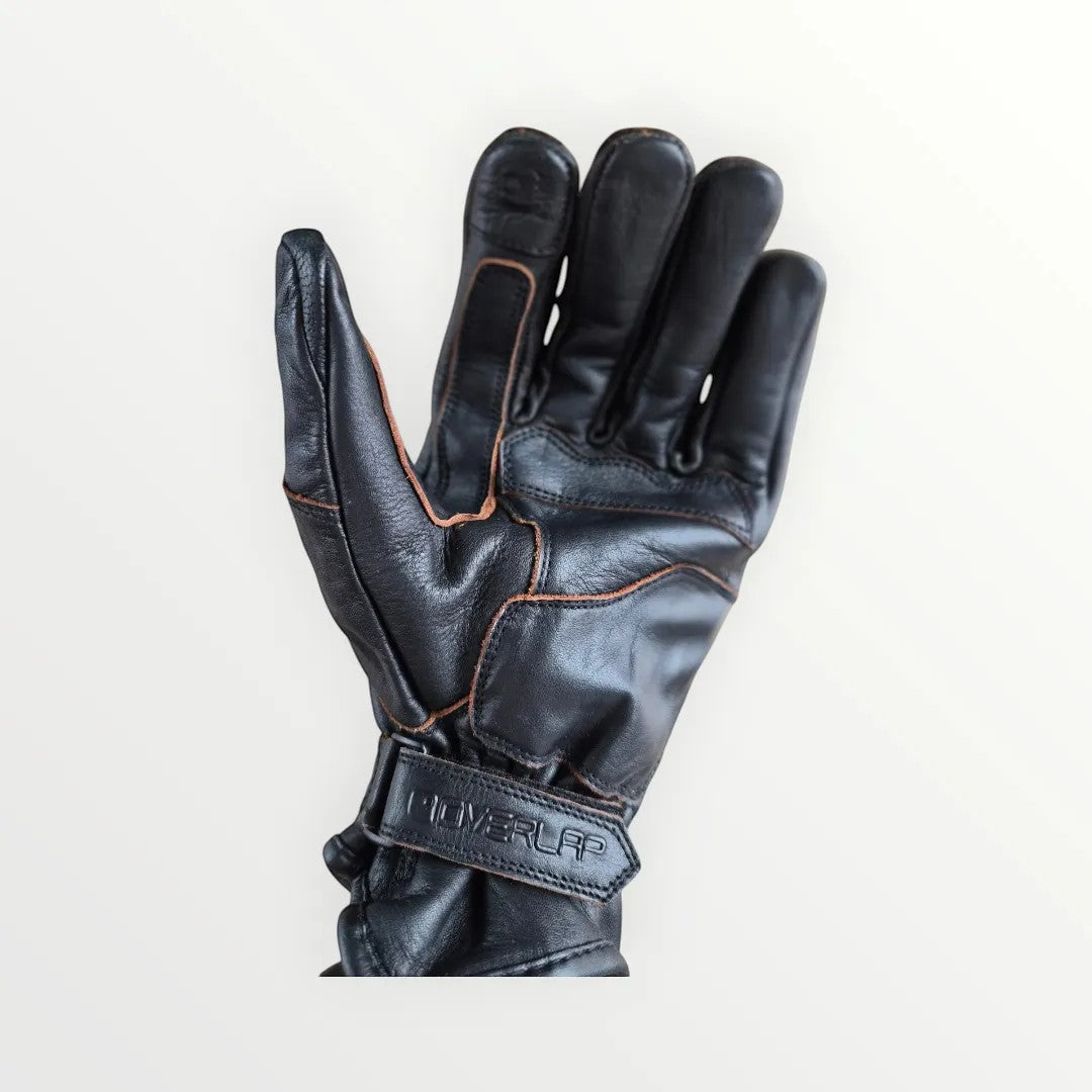 VelvetMoto black leather riding gloves with contrast stitching and adjustable wrist strap.