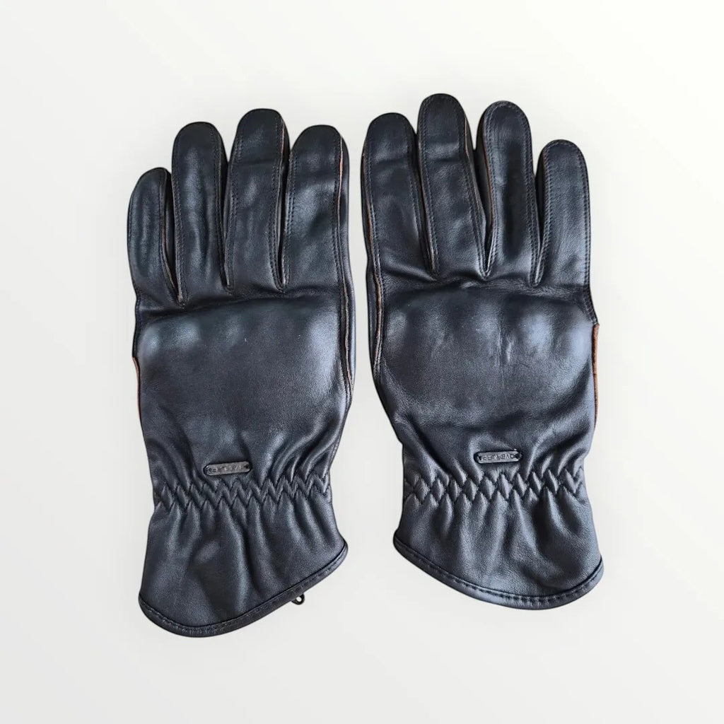 VelvetMoto black leather riding gloves with contrast stitching and adjustable wrist straps.