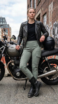 VelvetMoto women's sage green moto leggings with cargo pockets, paired with a black t-shirt and leather jacket.